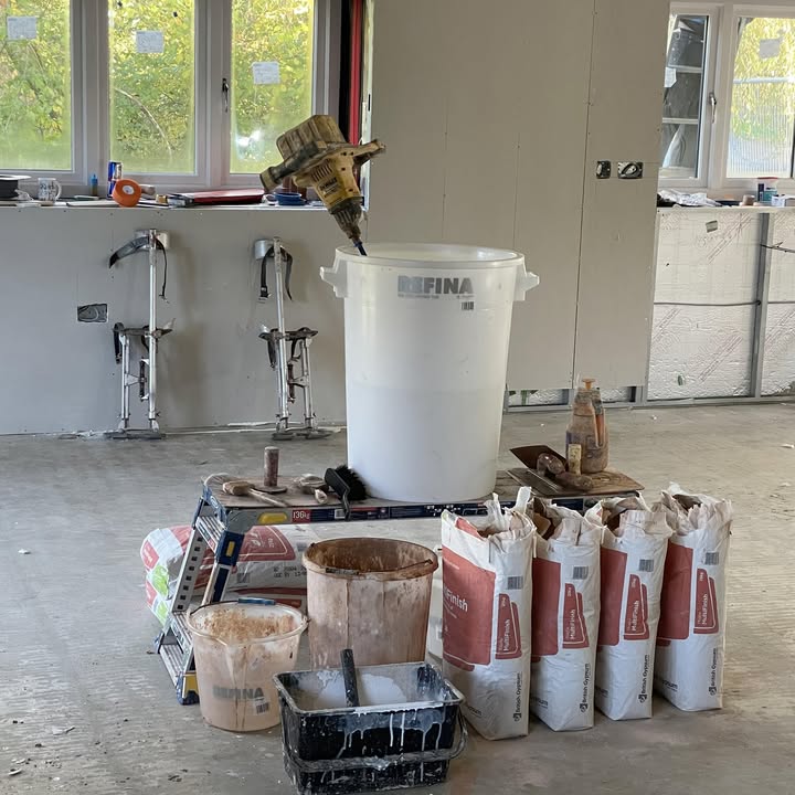 Plaster bags, mixing tubs and stilts set up on a job